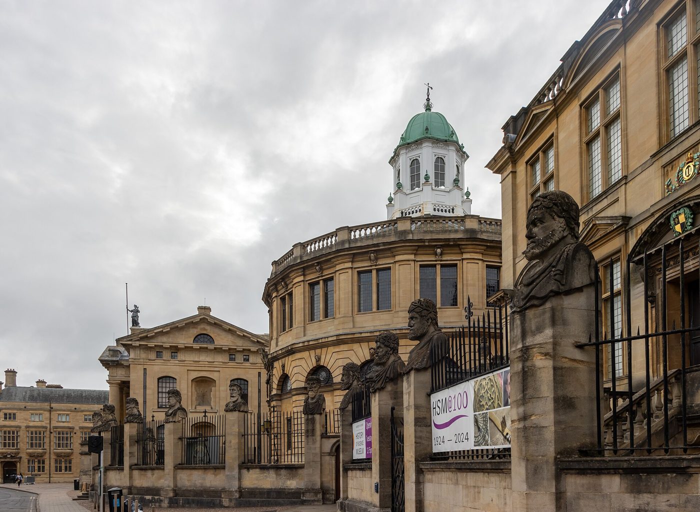 The Sheldonian Theatre and its cupola behind the stone heads on Broad Street