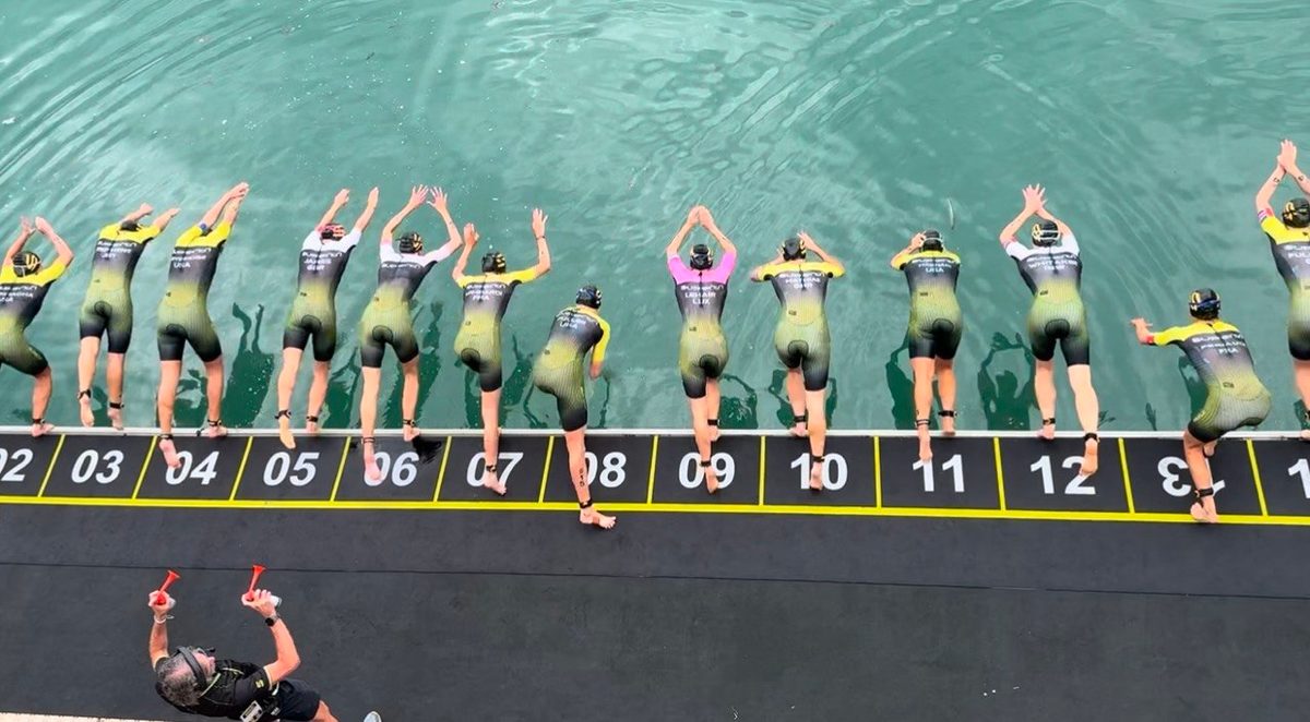 Professional triathletes diving from numbered start positions into the harbour at St Helier